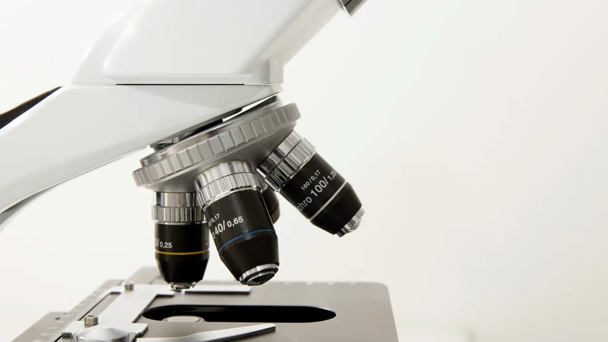 Close-up of a laboratory microscope with objective lenses positioned over a slide stage