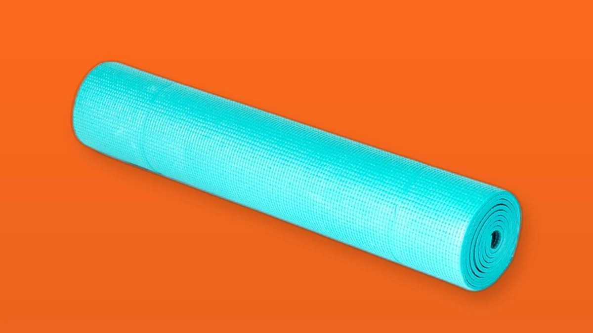 A rolled teal yoga mat on an orange background, photo illustration