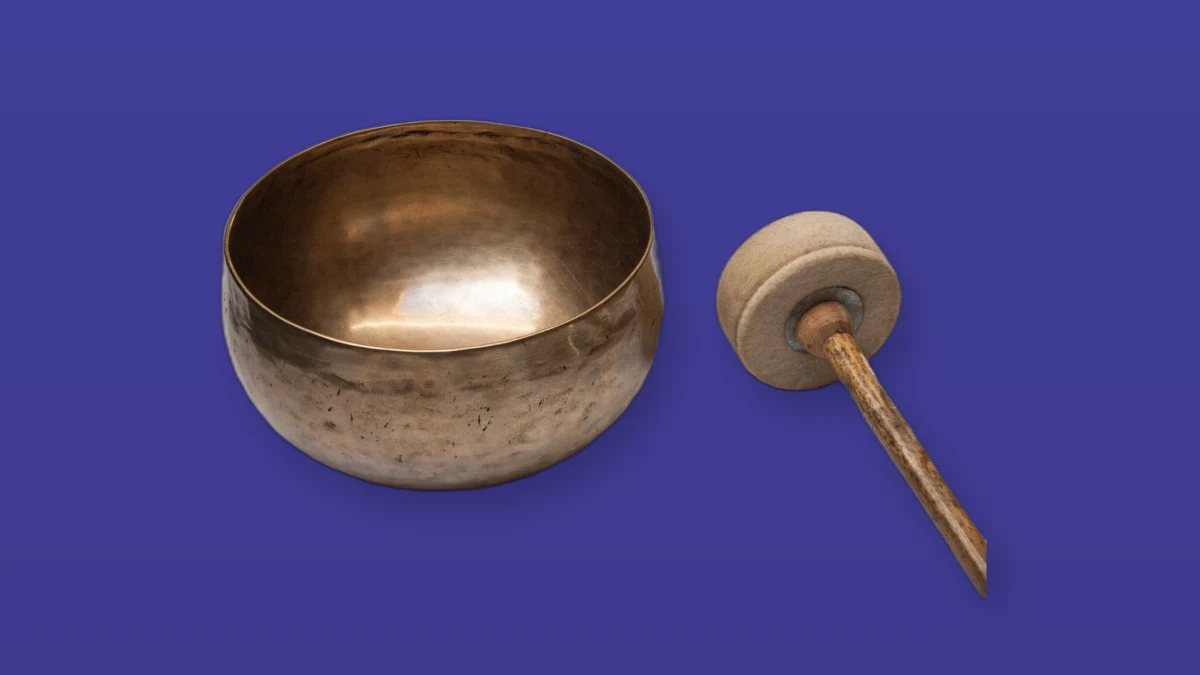 Photo illustration of a brass Tibetan singing bowl and wooden mallet on a violet background