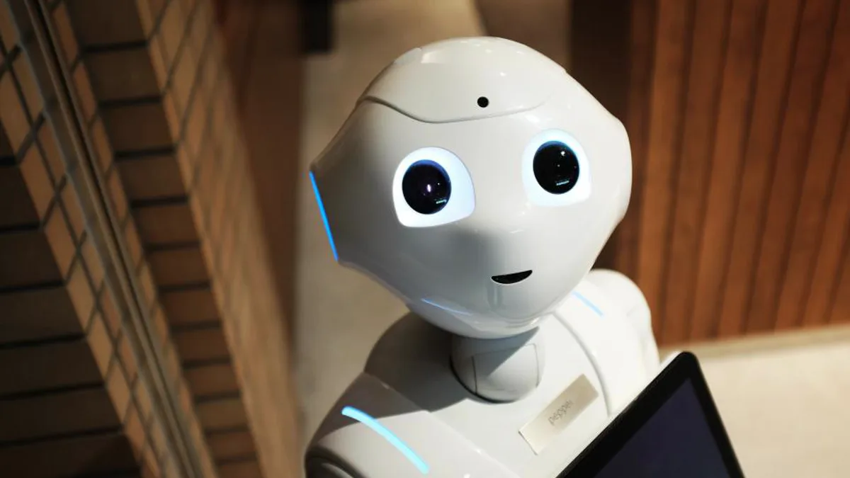 White humanoid robot with large dark eyes and blue light accents