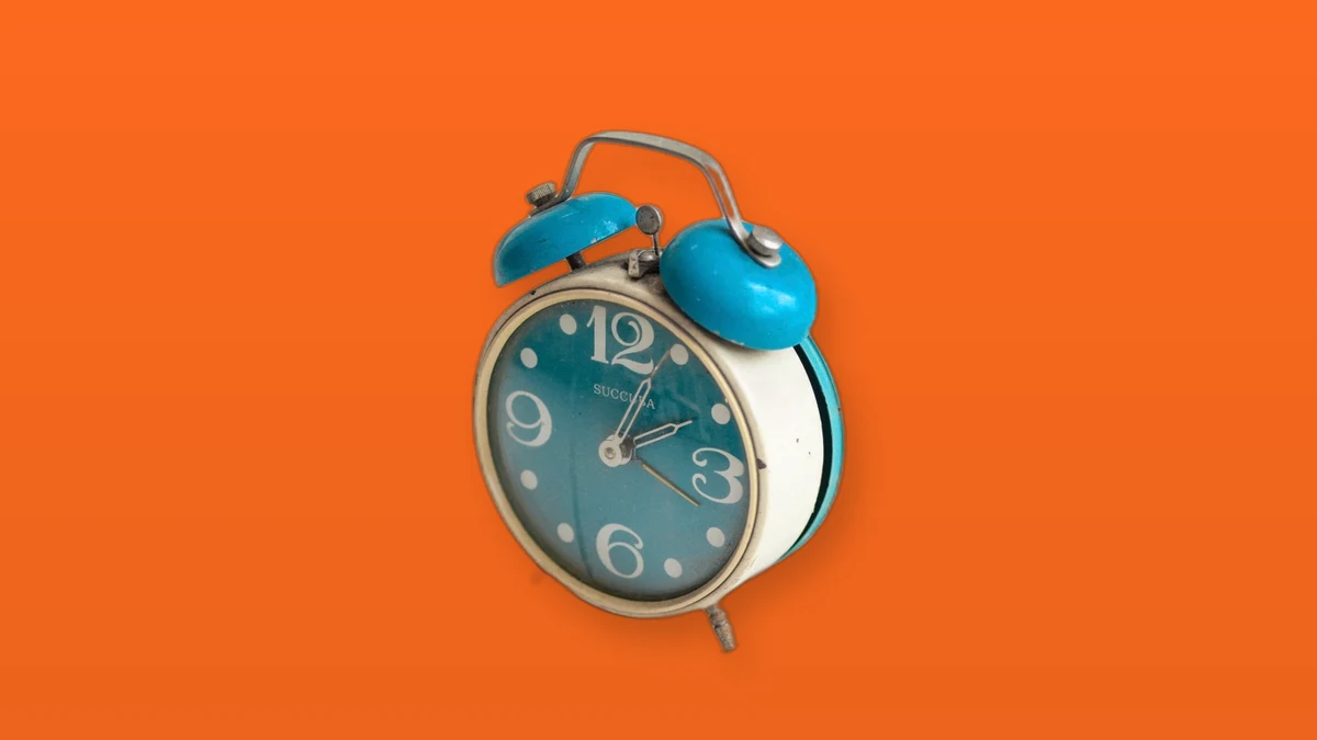 Photo illustration of a twin-bell alarm clock on a colored background representing the workweek