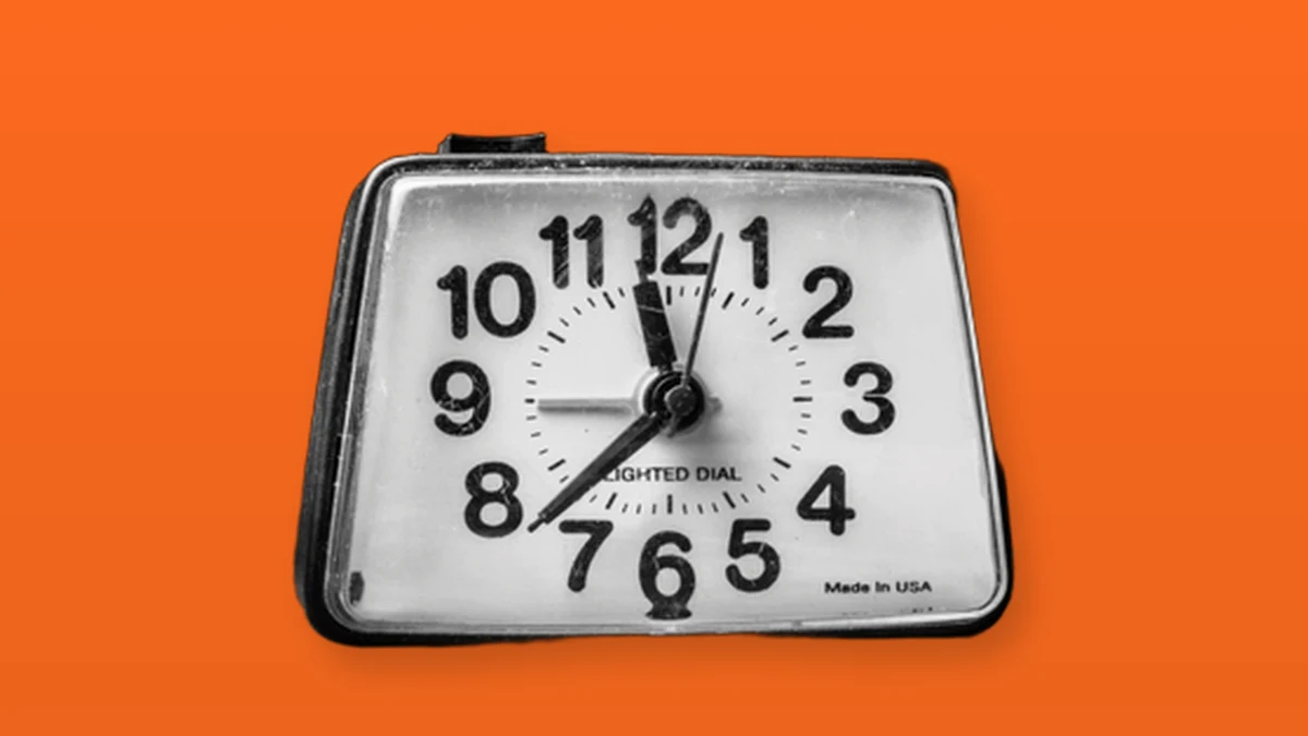A vintage alarm clock isolated on an orange background to symbolize aging