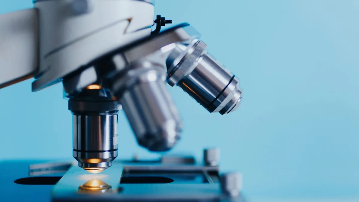 Close-up photograph of a laboratory microscope focused on a glass slide