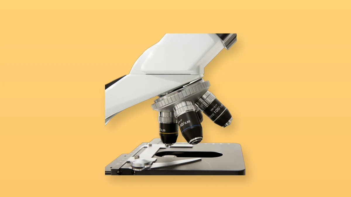 Laboratory microscope isolated on a warm peach background