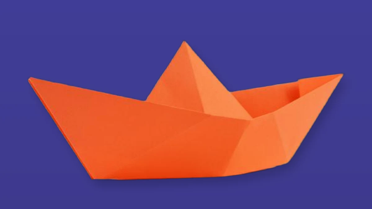 Orange paper boat isolated on a deep violet background