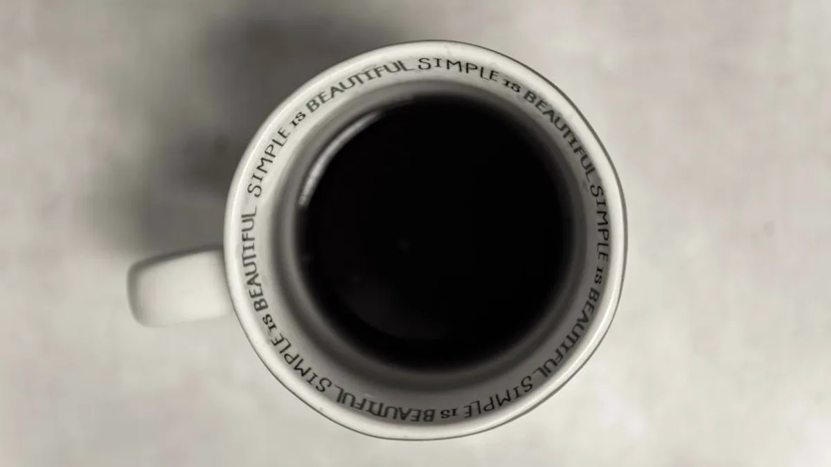 Black coffee in a white ceramic cup viewed from above