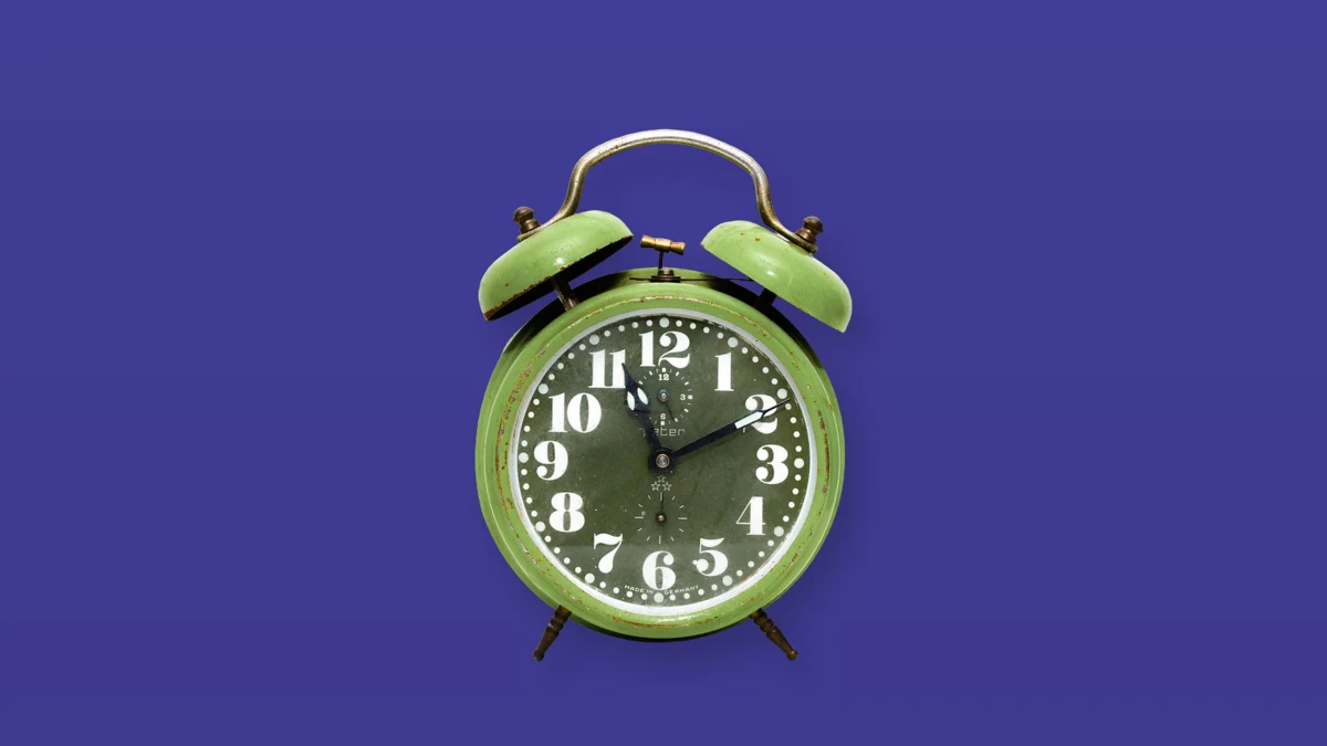 Green alarm clock isolated on a violet background