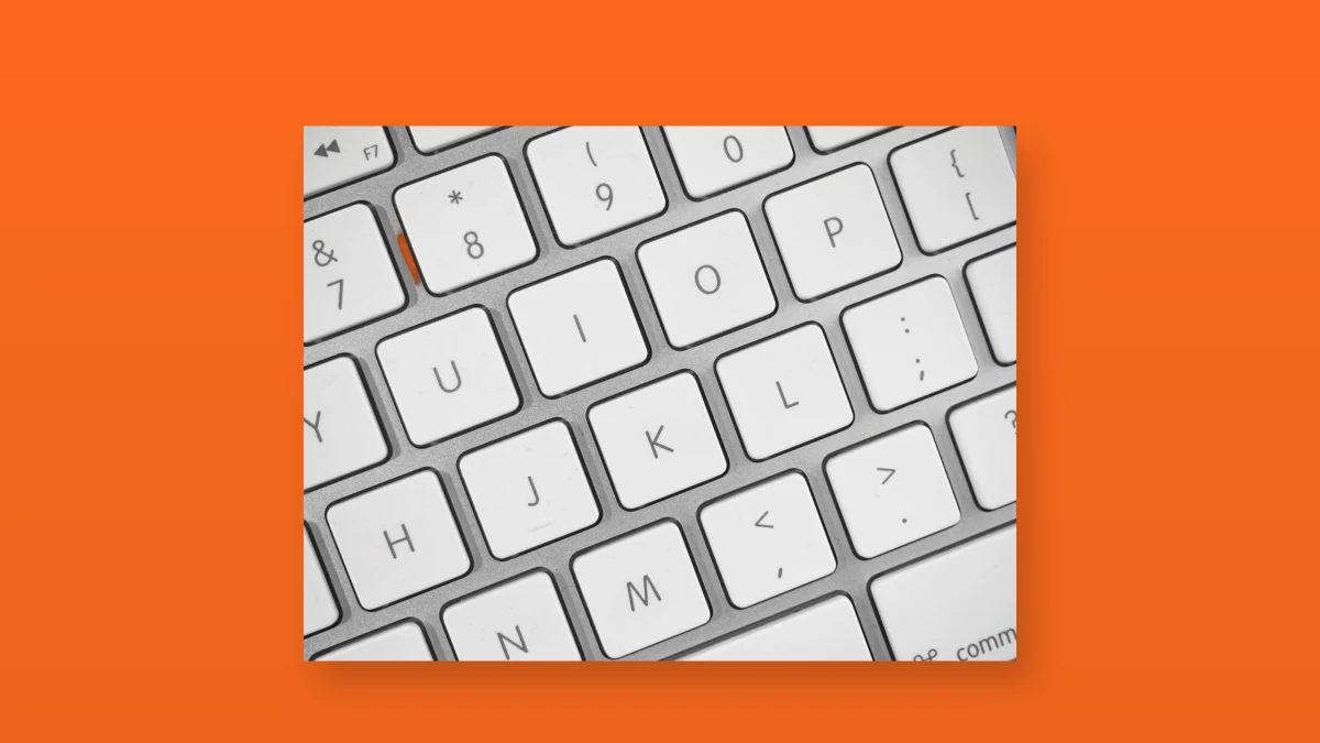 White computer keyboard isolated on an orange background