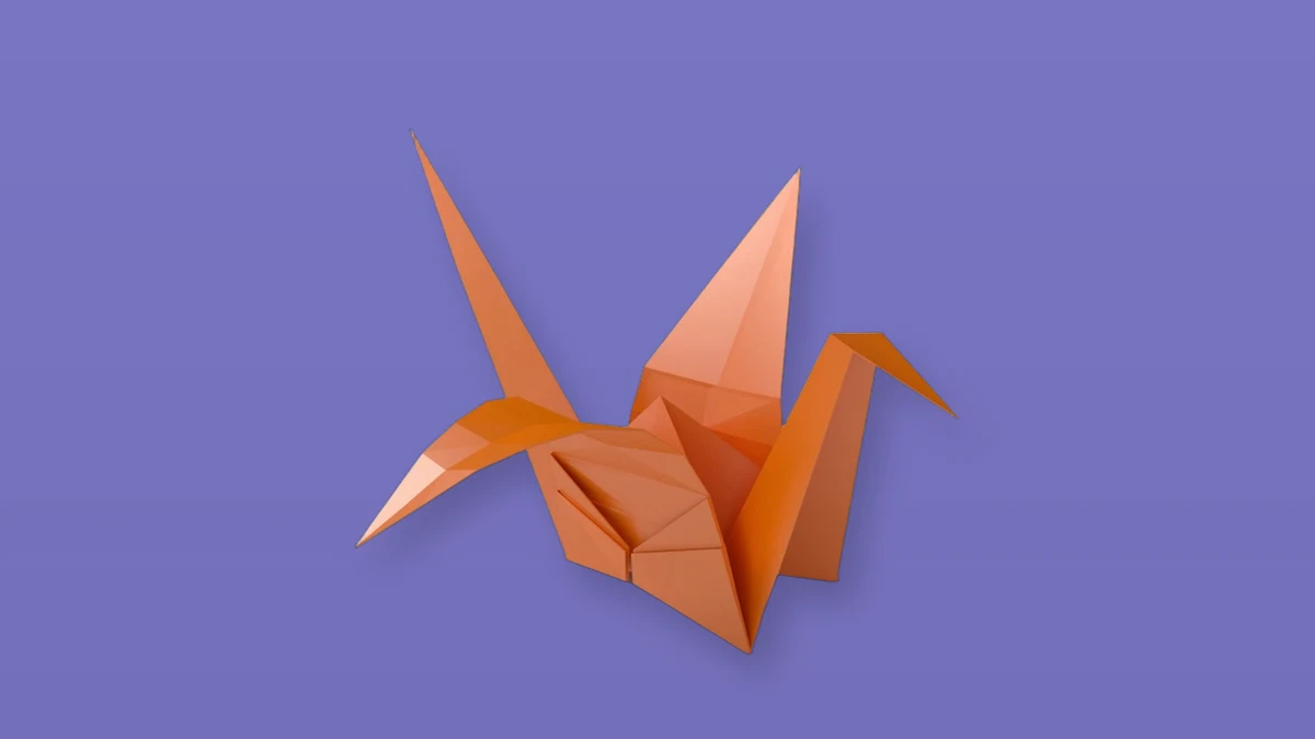 Orange origami crane isolated on a lavender background