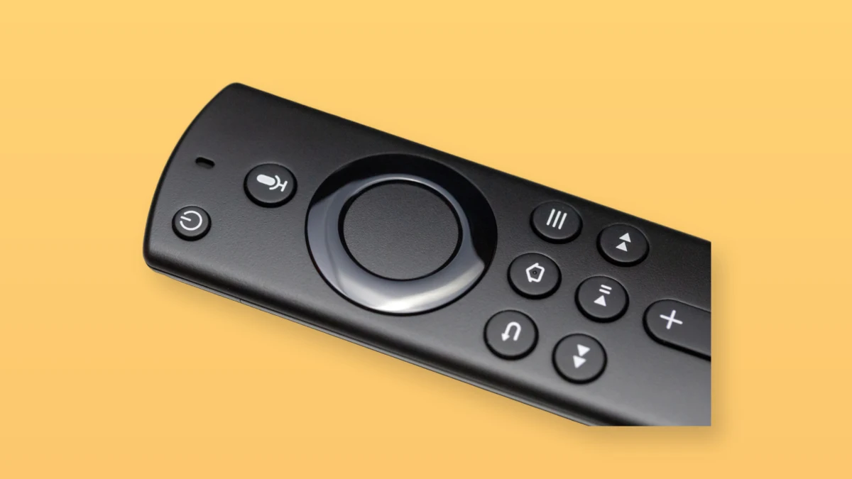 Photo illustration of a black television remote on a warm peach background
