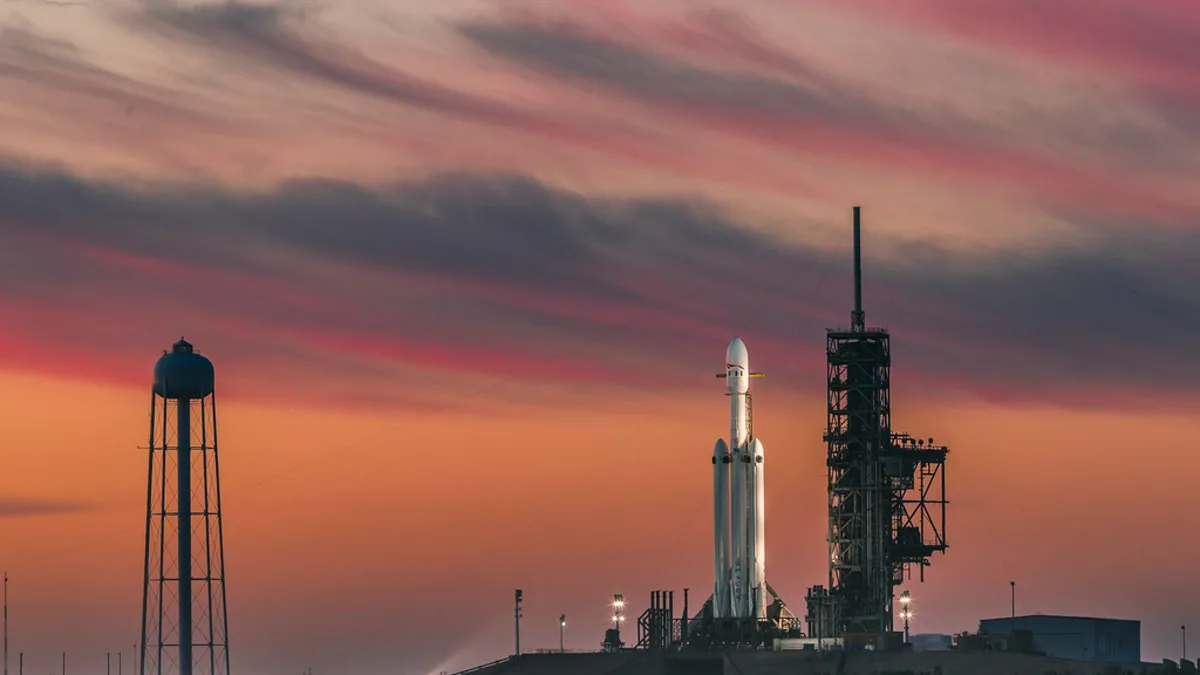 A SpaceX rocket standing on its launch pad at sunset