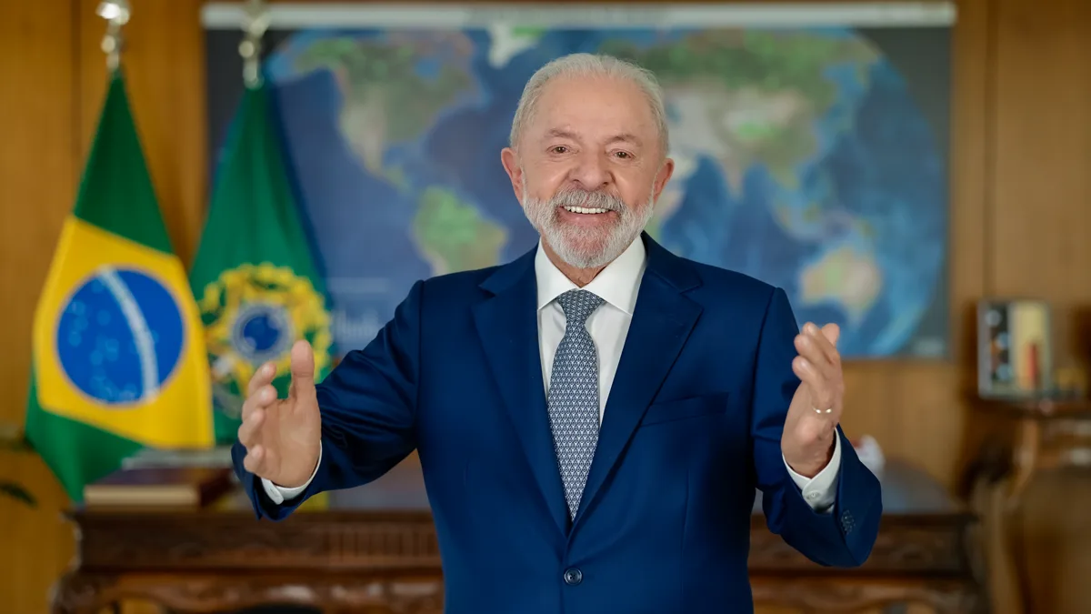 Brazilian President Luiz Inacio Lula da Silva speaking at a lectern beside the national flag