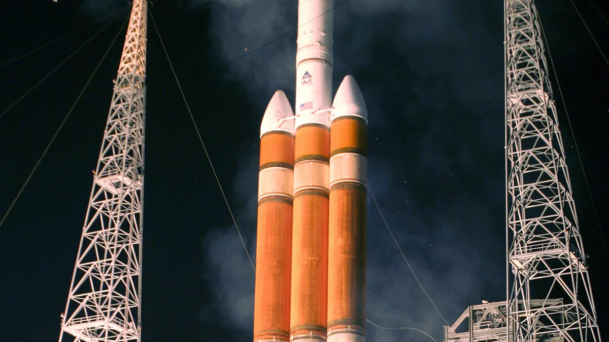 A Delta IV Heavy rocket lifting off at night carrying a Defense Support Program early warning satellite