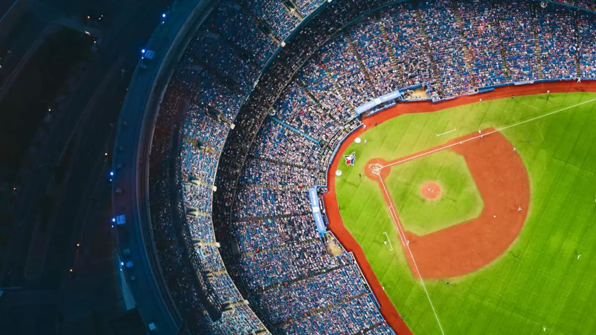 Aerial view of a packed baseball stadium and infield at dusk