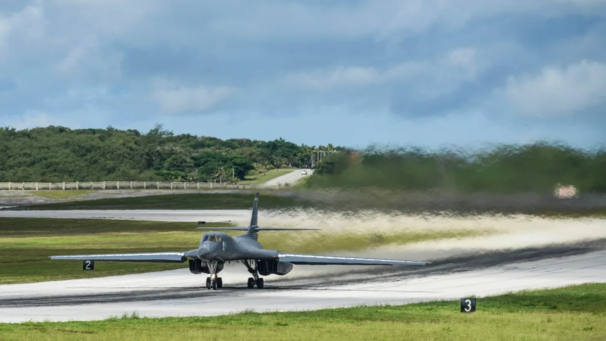 A US Air Force B-1B Lancer bomber on a runway with heat haze rising behind it