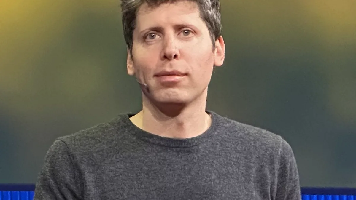 Sam Altman wearing a headset microphone while speaking on stage