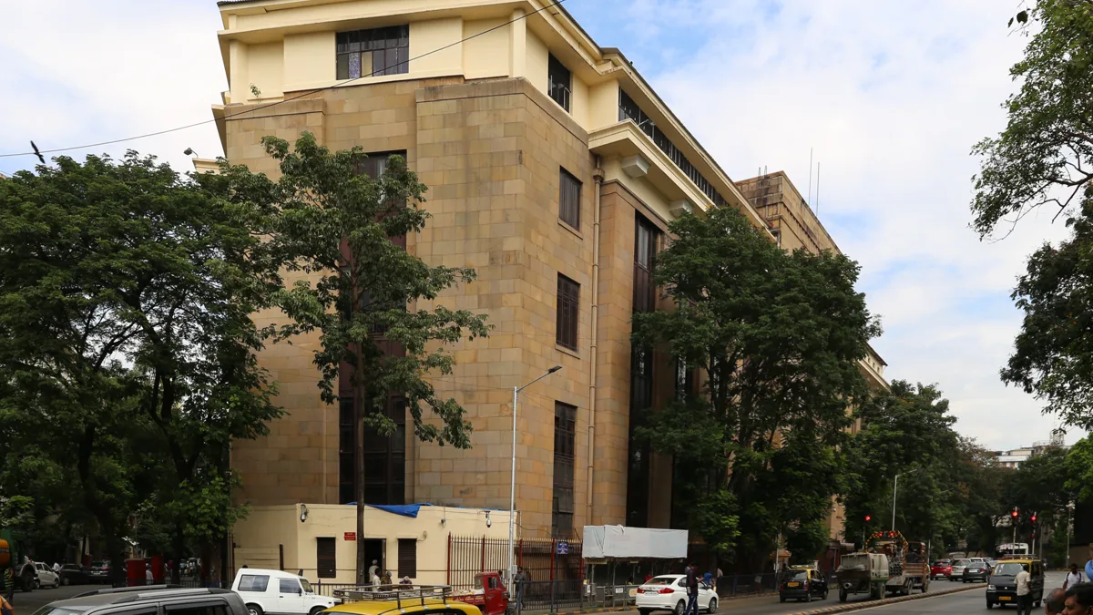The stone facade of the Reserve Bank of India building on a street in Mumbai