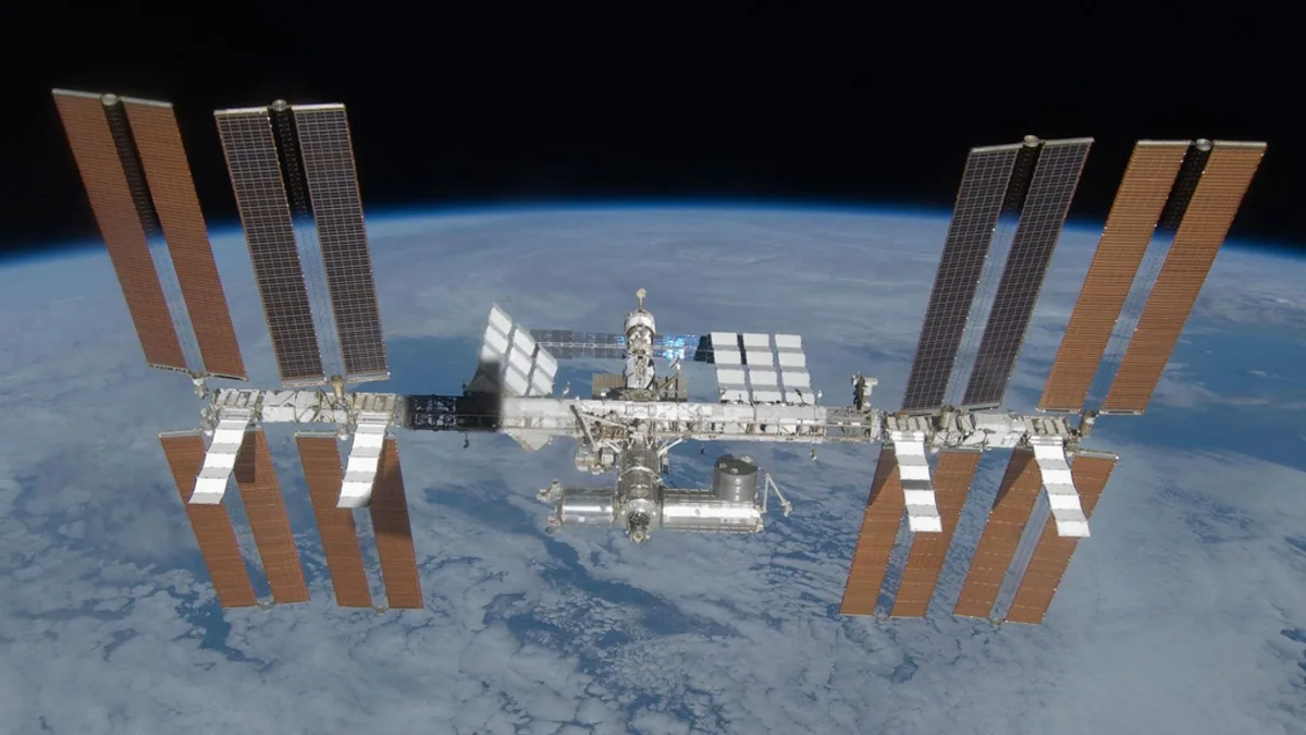 The International Space Station in orbit above Earth with its solar arrays extended