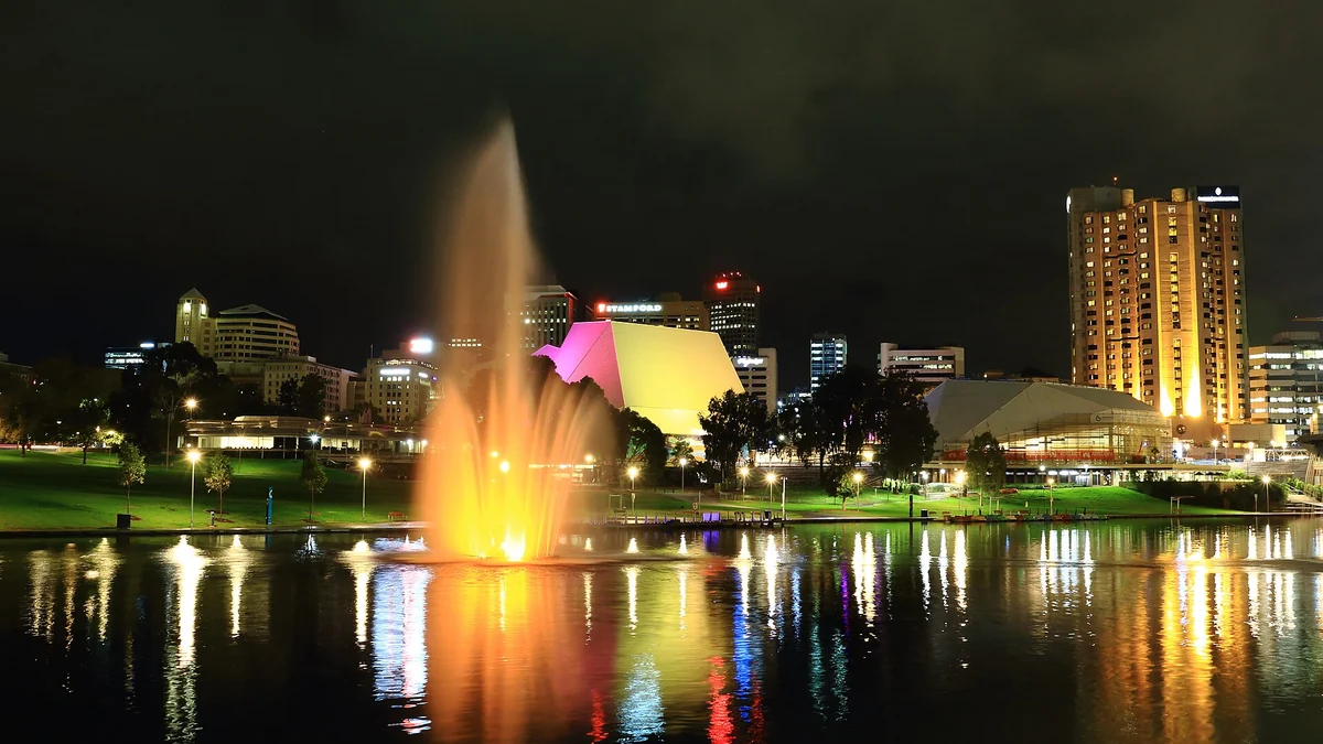 The Adelaide skyline at night across the River Torrens with the illuminated fountain