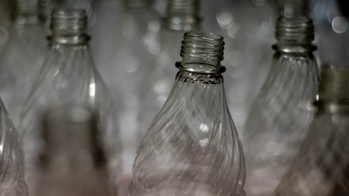 Close-up of empty clear plastic drink bottles lined up in low light