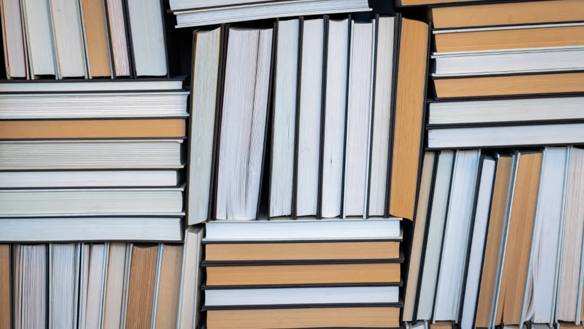 Stacks of hardback books viewed from above on a shelf