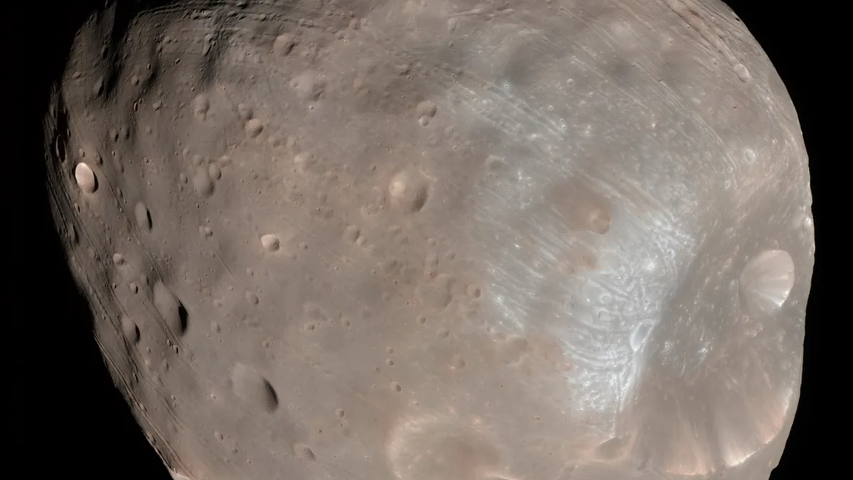 Close view of the cratered Martian moon Phobos against black space