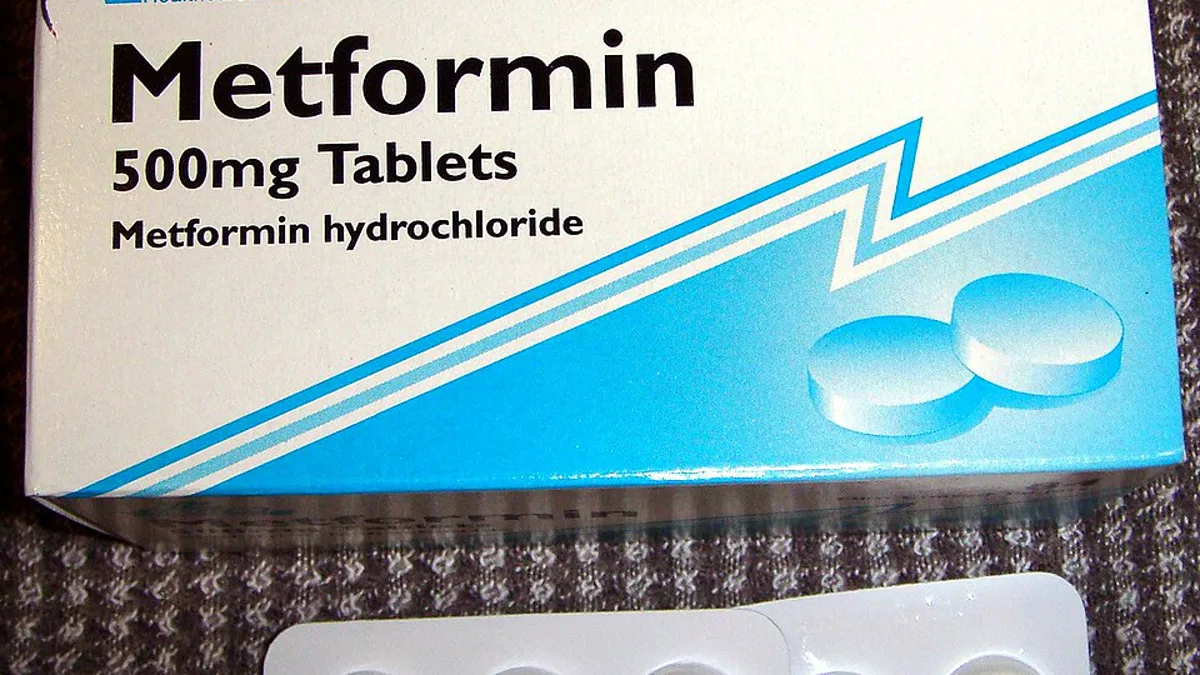 A box of metformin 500mg tablets beside two blister packs