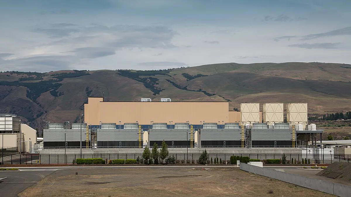 A Google data center building with rows of cooling units set against dry hills in The Dalles, Oregon