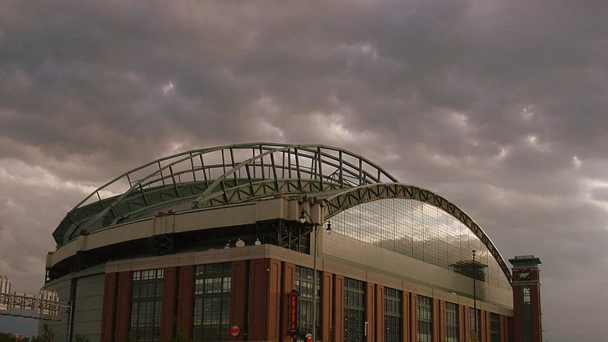 The exterior of the Milwaukee Brewers ballpark and its fan-shaped roof under heavy storm clouds