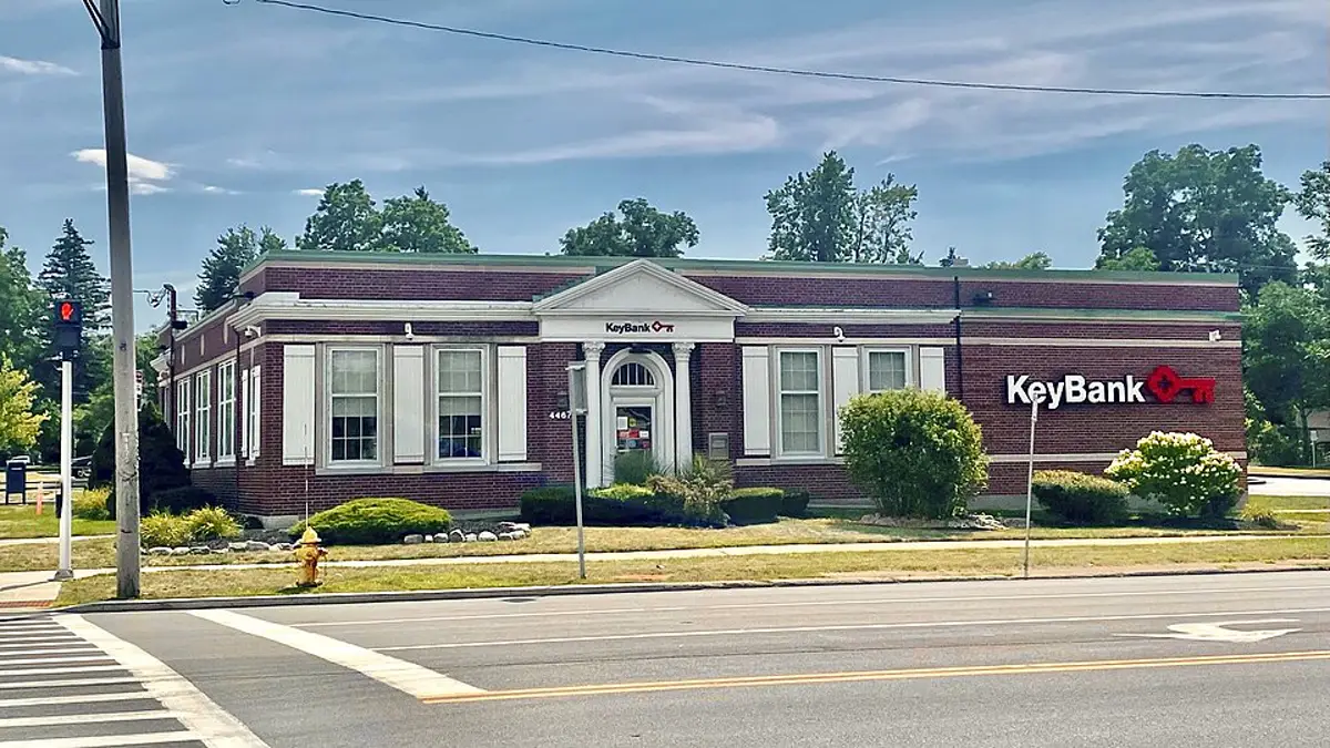 Exterior of a KeyBank branch on a street corner with the bank logo on its brick wall