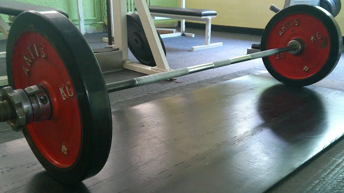 A loaded Olympic barbell resting on a weightlifting platform